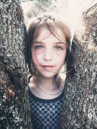 Portrait of girl smiling on tree trunk