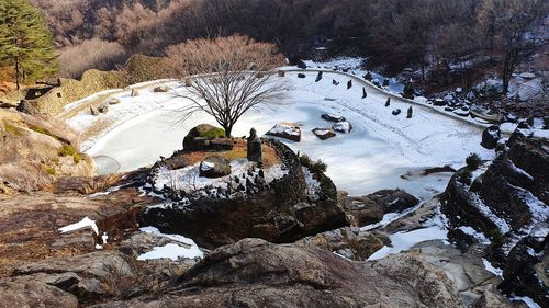 High angle view of stream amidst rocks in winter