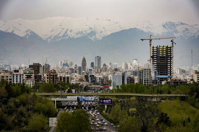 Aerial view of buildings in city against sky