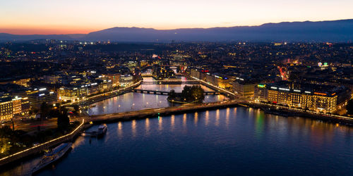 High angle view of illuminated bridge over river against sky at sunset