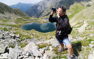 Woman looking through binoculars on mountain