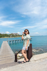 Full length portrait of woman against sea