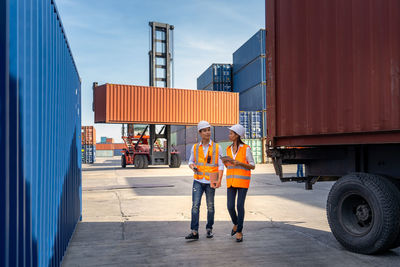 Engineers are overseeing the transportation of cargo with containers inside the warehouse.