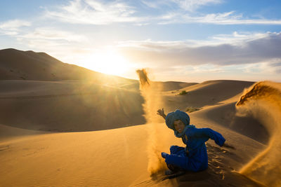 Man sitting on sand dune