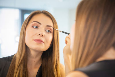 Close-up of woman applying make-up