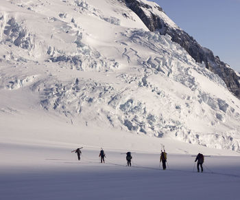 People hiking on snowcapped mountain