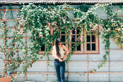Woman standing by plants