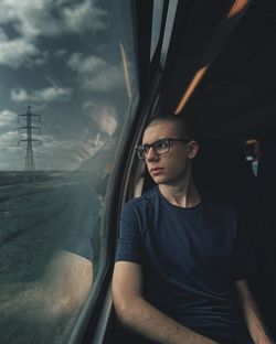 Portrait of young man sitting in train 