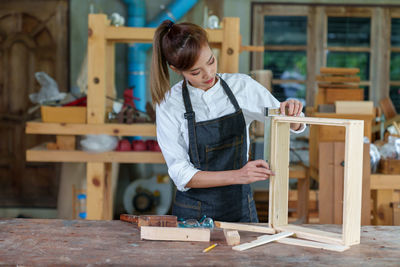 Portrait of beautiful asian woman carpenter dealing with handicraft