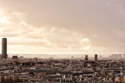 View of cityscape against cloudy sky