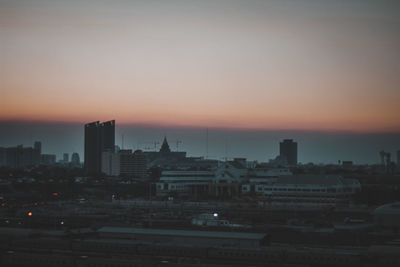 Buildings in city against sky during sunset