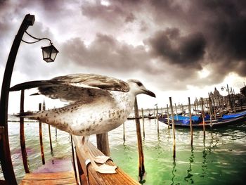 Boats in sea against cloudy sky