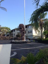 Statue in front of building against sky