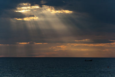 Scenic view of sea against cloudy sky at sunset