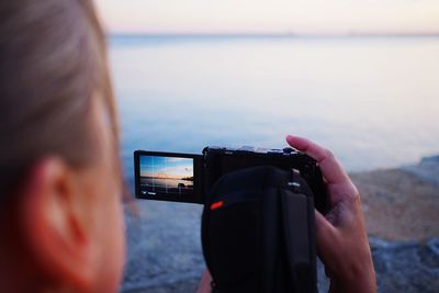 Cropped image of man holding camera