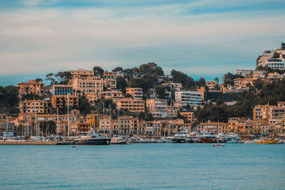 Buildings by sea against sky