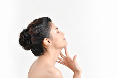 Portrait of young woman against white background