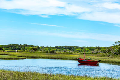 Boat moored in lake against sky