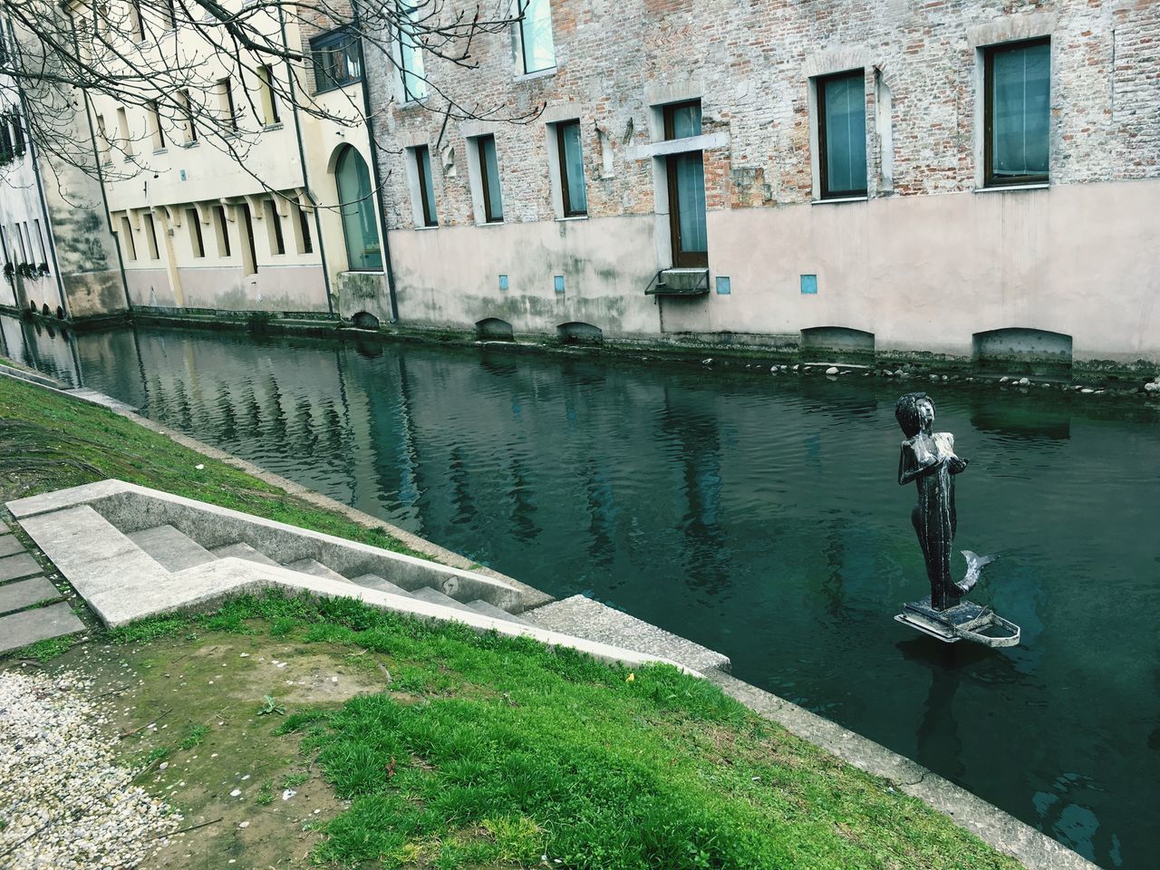 REFLECTION OF BUILDING IN WATER AGAINST SKY