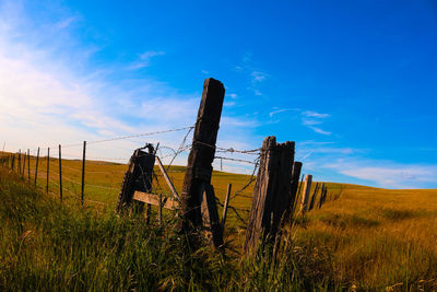 Wooden fence on field against sky