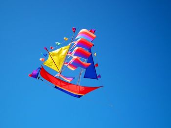 Low angle view of flag against clear blue sky