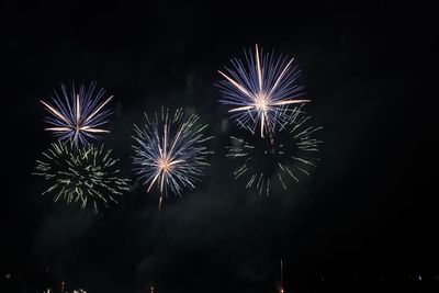 Low angle view of firework display at night