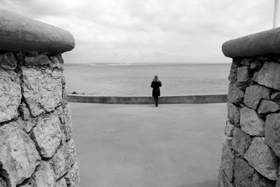 Rear view of woman standing at promenade against sky