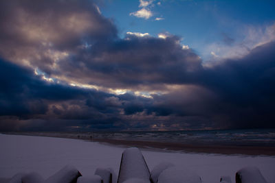 Scenic view of sea against dramatic sky during sunset