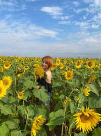 Full length of woman on sunflower field against sky