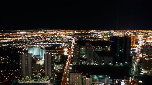 Illuminated cityscape against sky at night