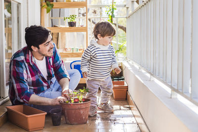 Friends standing on potted plant