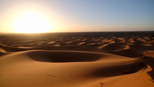 Scenic view of sand dunes against clear sky