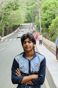 Portrait of young man standing on road