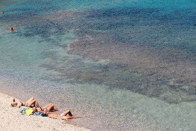 High angle view of friends relaxing at shore