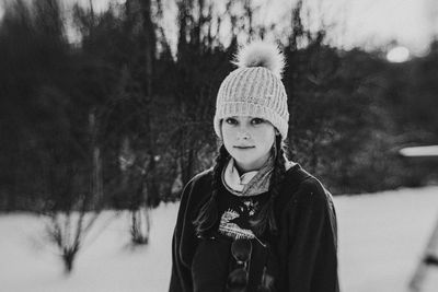 Portrait of smiling boy standing on snow covered field