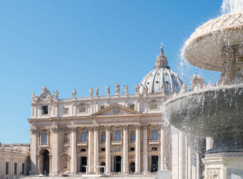 Fountain at st peter basilica against clear blue sky