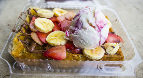 High angle view of ice cream with fruits in bowl on table