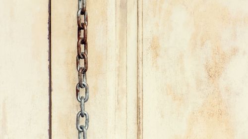 Close-up of chain against wall
