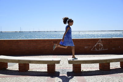 Full length of woman standing on footpath