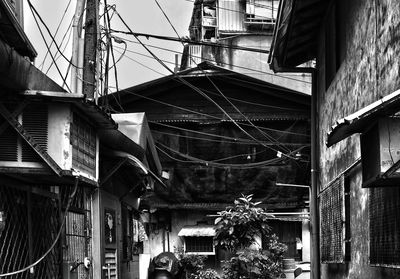 Cables hanging amidst old buildings in city