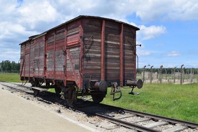 Train by railroad tracks against sky