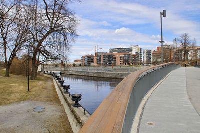 Bridge over river in city against sky