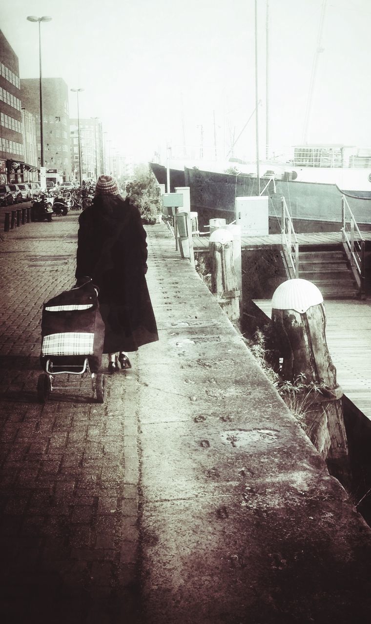 transportation, mode of transport, rear view, lifestyles, sitting, men, full length, person, leisure activity, nautical vessel, clear sky, land vehicle, sunlight, street, day, outdoors, chair