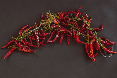 Close-up of red chili peppers on table against black background