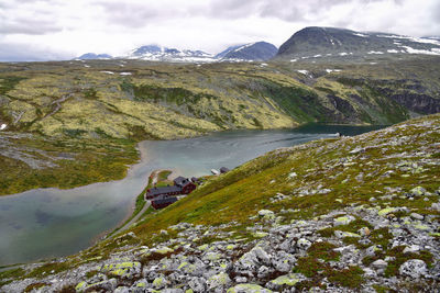 Scenic view of river and mountains against cloudy sky