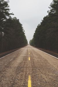 Road amidst trees against sky