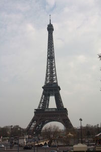 Tower in city against cloudy sky