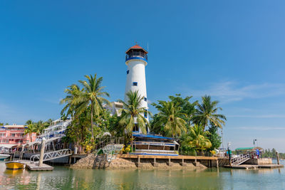 Lighthouse by sea against sky