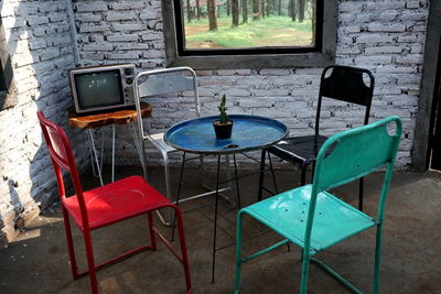 Empty chairs and table against wall