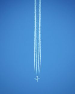 Low angle view of vapor trail against blue sky